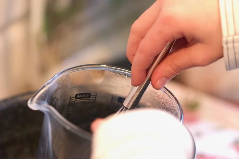 Faire fondre la cire au bain Marie pour réaliser des bougeoirs dans des coquilles d'oeufs 